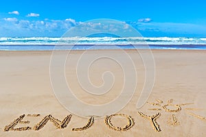 Enjoy inscription on wet beach sand under the sun drawing and se