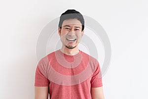 Enjoy and laughing face of man in red t-shirt on isolated background.