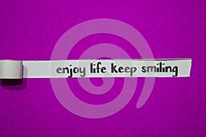 Enjoy life keep smiling, Inspiration, Motivation and business concept on purple torn paper