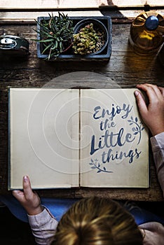 Enjoy little things phrase written on notepad