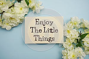 Enjoy the little things text message top view on blue background