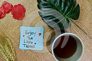 Enjoy The Little Things write on sticky notes isolated on Wooden Table