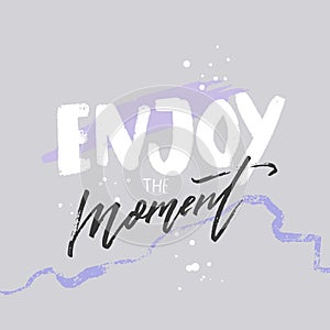 Enjoy the moment. Positive inspirational quote on abstract pastel violet background. Carpe diem. Hand lettering saying.