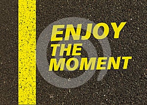 Enjoy the moment written on the road.