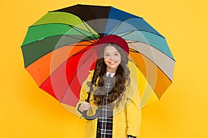 Enjoy rain concept. Kid girl happy hold colorful rainbow umbrella. Rainy weather with proper garments. Bright umbrella
