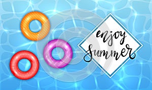 Enjoy Summer and Colored Swim Rings on Water Background