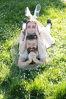 Enjoy summer vacation. Happy couple relax on sunny outdoor. Sensual woman lying on bearded man on green grass. Carefree