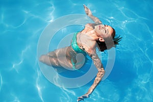 Enjoy the summer. Woman relaxing in the pool water