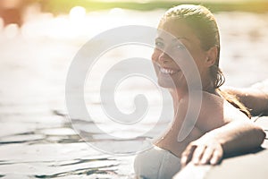 Požívať leto. žena relaxačné v bazén voda 
