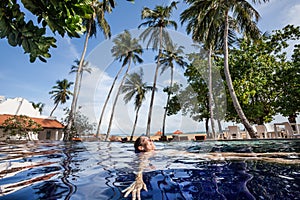 Enjoy the tropical summer. Woman relaxing in the pool water