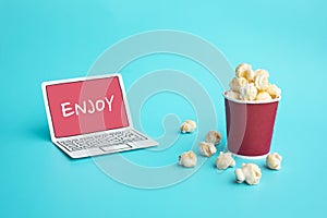 Enjoy with vdo entertainment or movie concepts with text on paper art laptop and pop corn on color photo