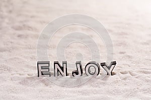 Enjoy word on white sand