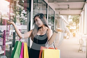 Enjoying of asian young woman shopping in the outlet mall with carrying paper bags