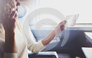 Enjoying business travel concept. Young beautiful brunette tourist girl travelling on the train sitting near the window