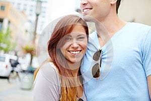 Enjoying the City life in Summer. Portrait of a beautiful girl being embraced by her boyfriend on a city street.