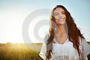 Enjoying the countryside. an attractive young woman standing outside in a field.