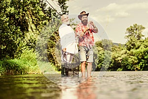 Enjoying day fishing. retired dad and mature bearded son. friends men with fishing rod and net. hobby of businessman