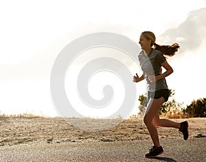 Enjoying an early morning jog. a sporty young woman out for a run.