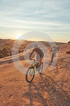 Enjoying the freedom of nature. Full length shot of two young male athletes mountain biking in the wilderness.