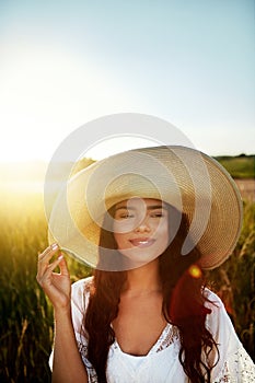 Enjoying the fresh air. an attractive young woman standing outside in a field.