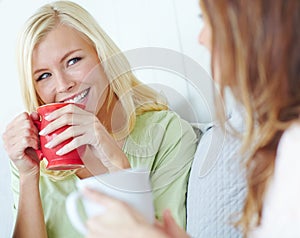 Enjoying good company and great coffee. Two attractive young women smiling while having coffee together.