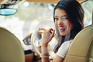 Enjoying her new car. an attractive young woman driving a car.