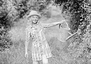 Enjoying her work with plants. nature protection. little girl farmer care plants. farming. spring country side village