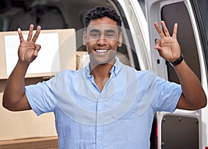 Enjoying his day of successful deliveries. Portrait of a young delivery man gesturing an okay sign while loading boxes