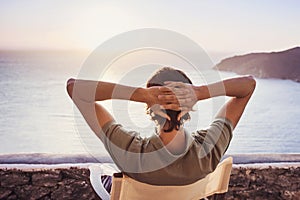 Enjoying life. Back side of young man looking at the sea. photo