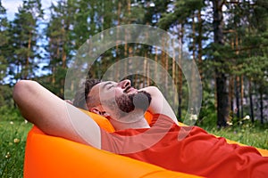 Enjoying life. A young man lies in a bivouac in the forest., relaxation, vacations, lifestyle concept