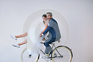 Enjoying lifes ride with my soulmate by my side. Studio portrait of a newly married young couple riding a bicycle