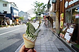 Enjoying milk ice cream soft serve cone with green tea flake pow