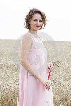 Enjoying the nature. Woman stay in wheat field and holding wheats