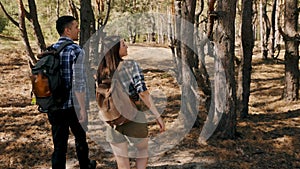 Enjoying nature. Young man and woman, couple in comfortable clothes walking forest on warm autumn day