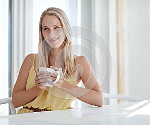 Enjoying a pleasant morning. an attractive young woman drinking a coffee at home.
