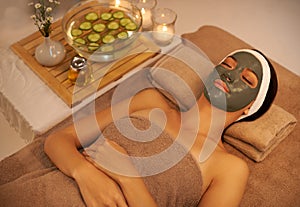 Enjoying a reviving facial mask. A young woman lying in a day spa with a face mask on.