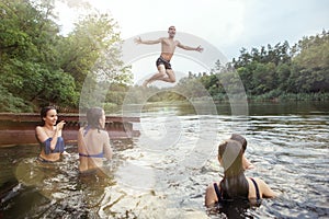 Enjoying river party with friends. Group of beautiful happy young people at the river together