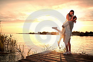 Enjoying By The River.Romantic couple in love dating at sunset at river