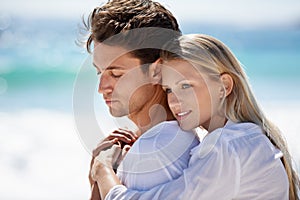 Enjoying a romantic getaway. A young couple having an intimate moment on the beach.