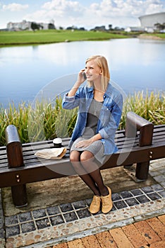 Enjoying some fresh air during my lunchbreak. an attractive woman using her phone during her lunchbreak in the park.