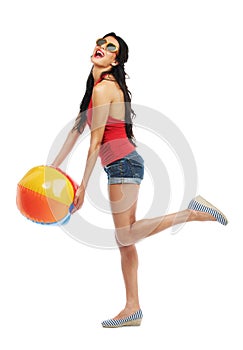 Enjoying some summer fun. Studio shot of an attractive young woman holding a beachball against a white background.