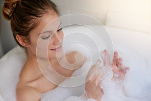 Enjoying some tranquil time in the tub. Cropped shot of a beautiful young woman relaxing in the bathtub.