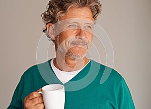 Enjoying something warm on a cold afternoon. Cropped studio shot of a handsome mature man holding a mug.