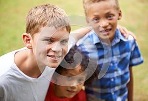 Enjoying Summer with my friends. Portrait of three young kids standing outside.