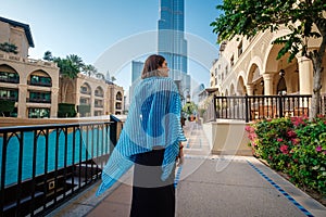 Enjoying travel in United Arabian Emirates. Young woman in dress walking on Dubai Downtown