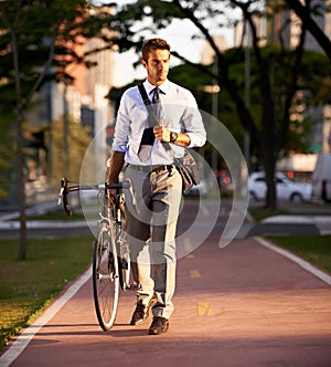 Enjoying the urban lifestyle. a businessman commuting to work with his bicycle.