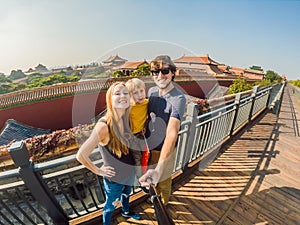 Enjoying vacation in China. Happy family with national chinese flag in Forbidden City. Travel to China with kids concept