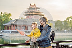 Enjoying vacation in China. Happy family with national chinese flag in Forbidden City. Travel to China with kids concept