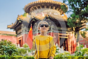 Enjoying vacation in China. Young boy with national chinese flag in Forbidden City. Travel to China with kids concept