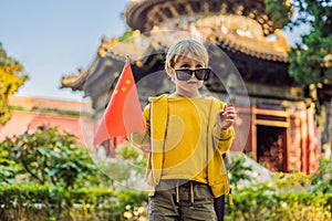 Enjoying vacation in China. Young boy with national chinese flag in Forbidden City. Travel to China with kids concept